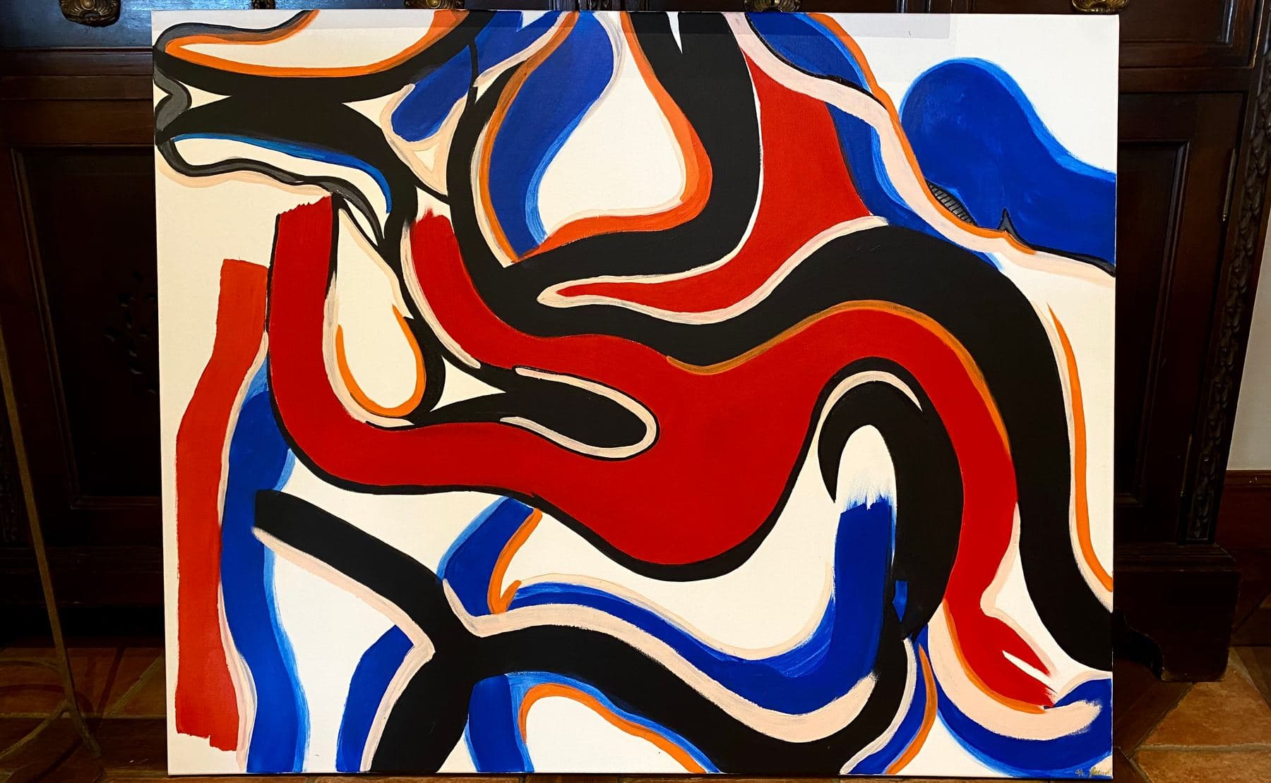 Grande peinture abstraite horizontale aux formes rouges, bleues, noires et orange, adaptée à un accrochage au-dessus d'un canapé